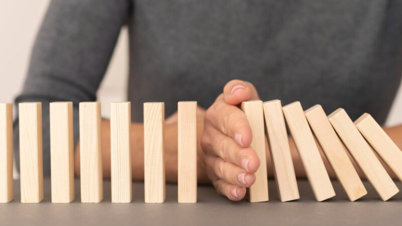domino-made-with-wooden-pieces-representing-finances-struggles